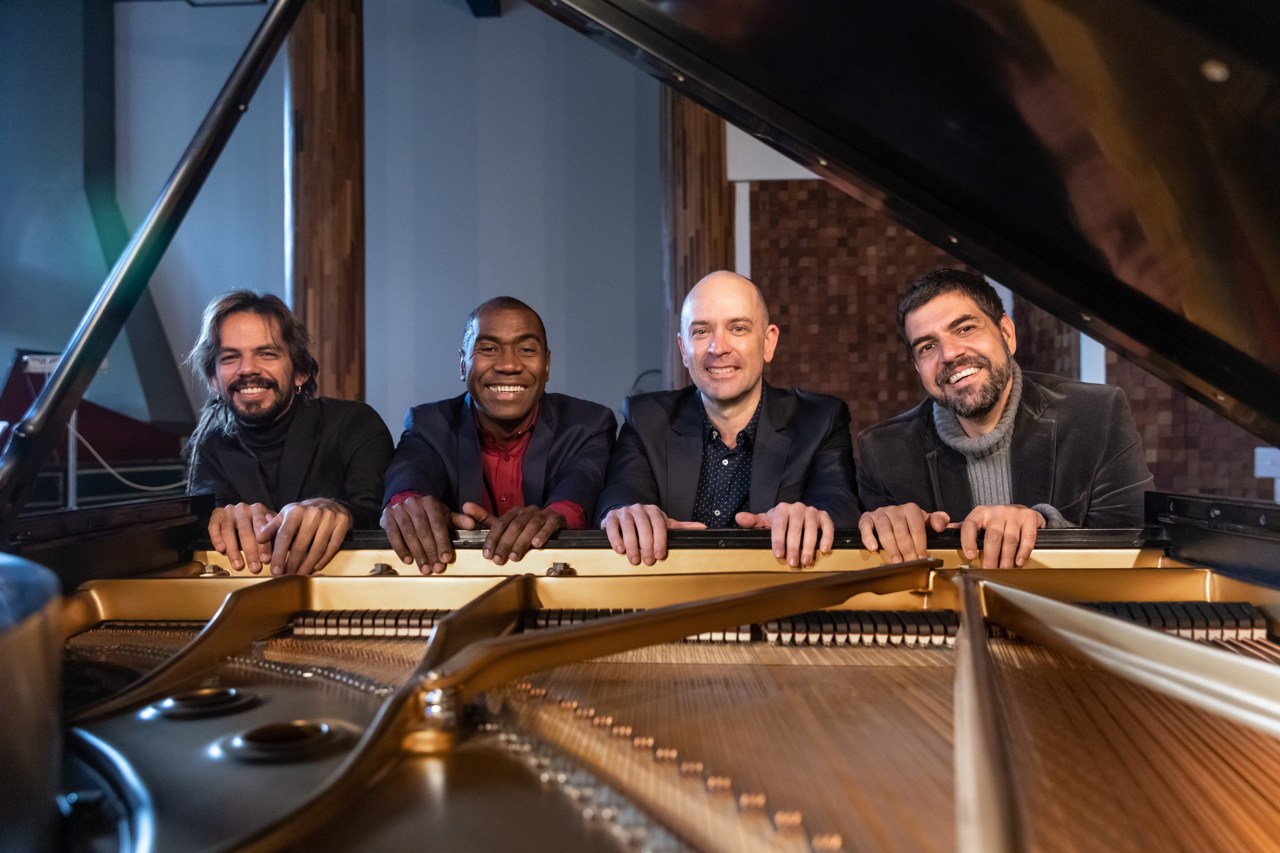 Na foto, os quatro músicos que integram o grupo sorriem e olham para a câmera apoiados num piano com a tampa aberta, cujas engrenagens estão à mostra