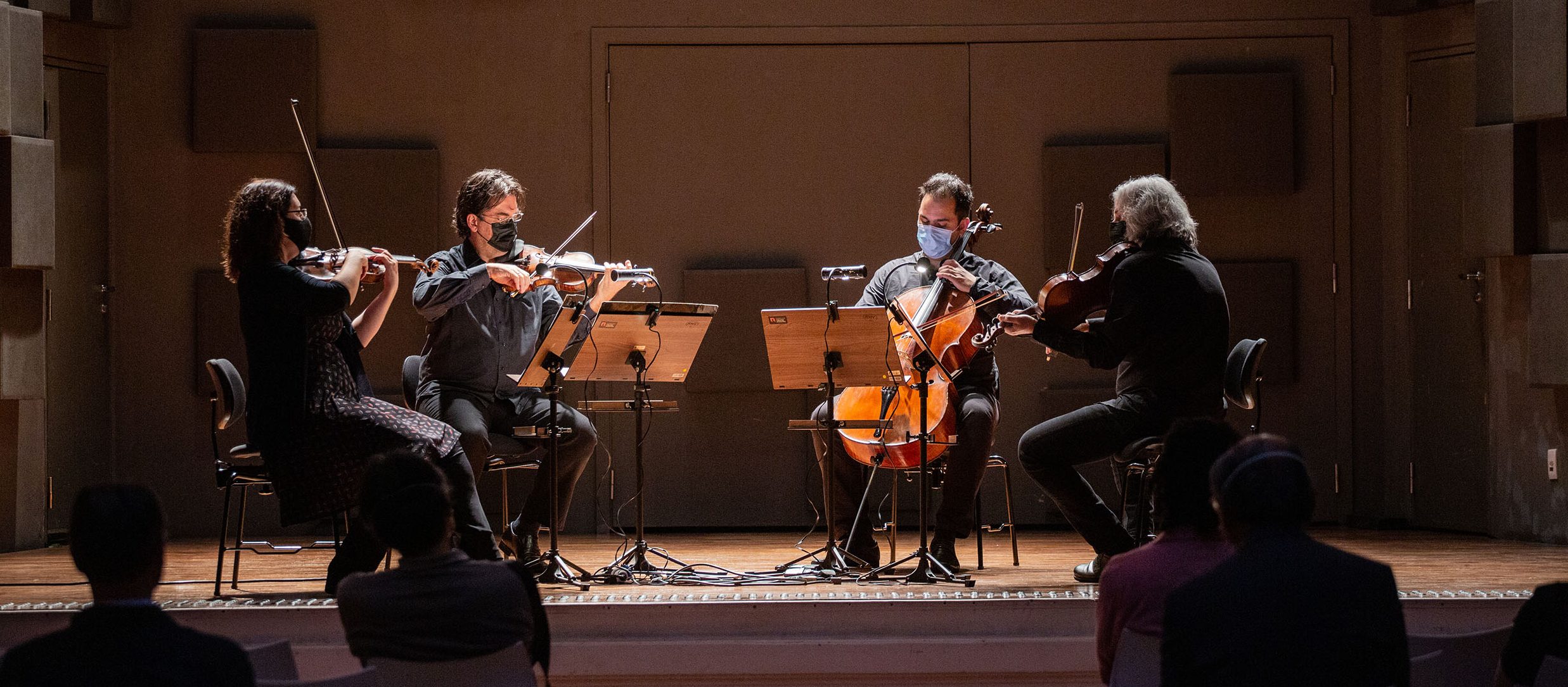Os quatro integrantes do Quarteto de Cordas tocam seus instrumentos durante apresentação